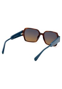 Ochelari de soare hexagonali, maronii, cu lentile degradate. Brate de culoare albastru închis din plastic, cu un accent auriu pe balama.