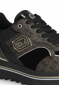 Sneaker neri con un motivo marrone texturizzato, dettagli metallici e una suola spessa nera con strisce bianche e dorate. Chiusura con lacci.