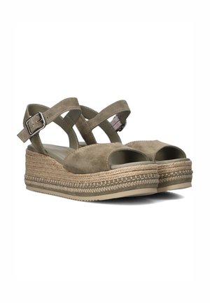Beige suède platform sandalen met open teenen, gekruiste banden, verstelbare metalen gesp en gevlochten jute accenten op de zool.
