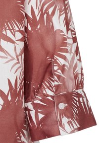 Langarmhemd mit weißem Grund und rustfarbenem Palmblattmuster. Es hat eine Knopfmanschette und eine glatte Stofftextur.