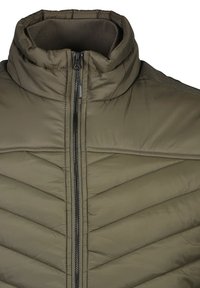 Olivgrön puffjacka med hög krage, horisontellt chevronmönster, dragkedjestängning fram och ribbad texturdetalj på kragen.