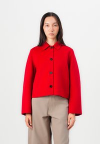 Rød ullblandingsjakke med krage, fem svarte knapper og brede ermer; kort design med en jevn tekstur og minimalistisk stil.