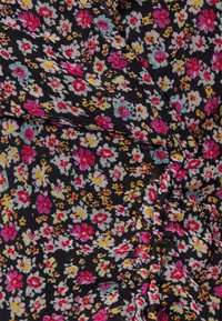 Tecido preto com um padrão floral apresentando flores em rosa, amarelo e azul. A textura parece leve, com detalhes de costura franzida.