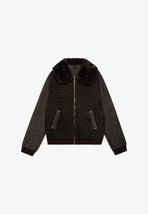 Veste marron avec un col en fausse fourrure, fermeture zippée, deux poches latérales, et un tissu texturé avec un motif subtil. Manches et ourlet côtelés.