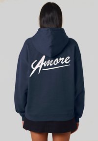 Felpa blu navy con grande scritta in bianco ricamata "Amore" sul retro. Presenta un cappuccio con cordino e polsini e orlo a coste.