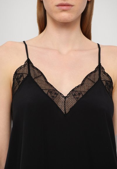 Zwarte cami met kant langs de halslijn en verstelbare spaghettibandjes. Soepele stof met een relaxed pasvorm en een v-vormig ontwerp.