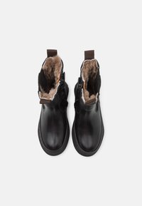 Black leather ankle boots with brown fur lining, dual zippers, and pull tabs. Smooth texture, round toe, and flat rubber sole.