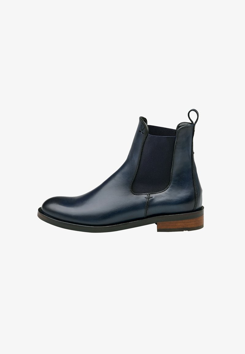 Botas Chelsea de cuero navy con paneles laterales elásticos, una lengüeta trasera y un tacón apilado marrón. Superficie lisa con un diseño elegante y ajustado.