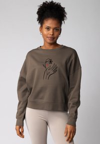 Bruine katoenen sweatshirt met een ontspannen pasvorm, met een omrandte handgrafiek, een bloem en een hart in het midden. Ribgebreide manchetten en zoom.