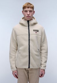 Beige fleece jacket with hood, zip front, side pockets, and black accents. Features a logo patch on the upper left chest area.