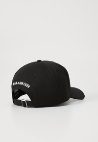 Gorra de béisbol de algodón negro con corona redondeada, visera curvada y etiqueta bordada en la parte posterior. Correa ajustable con hebilla de metal.