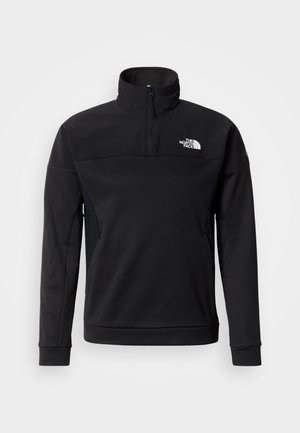 Black quarter-zip pullover made from soft, flexible material. Features a high collar, side mesh panels, and a logo on the chest.