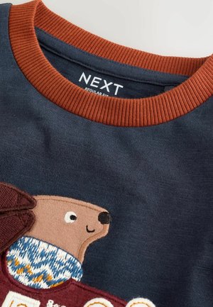 Granatowy sweatshirt z teksturowanym, pomarańczowym ściągaczem. Posiada brązowy haft z motywem zwierzęcym oraz wzorzystym detalem swetra.