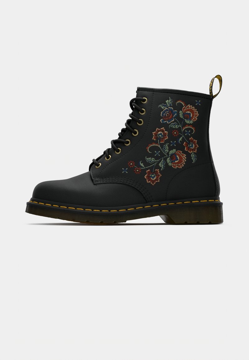 Botte noire à lacets avec broderie florale brune, bleue et verte sur le côté et coutures jaunes le long de la semelle.