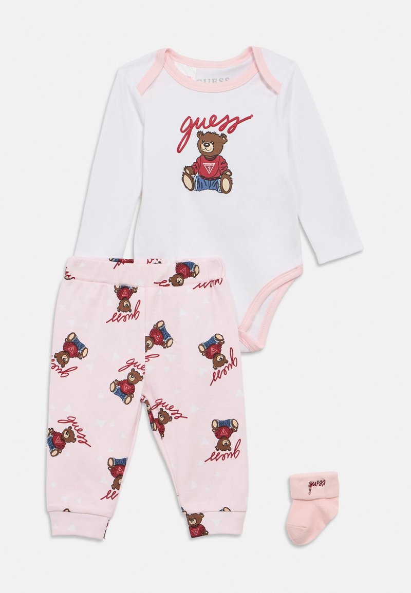 Λευκό ολόσωμο κορμάκι με μακριά μανίκια και γραφικό αρκούδας, συνδυασμένο με ροζ παντελόνι πιτζάμας με σχέδια αρκούδας και κείμενο, καθώς και ροζ καλτσάκι που ταιριάζει.