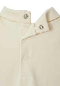 Cremfarbendes Poloshirt mit doppeltem Kragen, Druckknopfverschlüssen und weichem Baumwollmaterial.