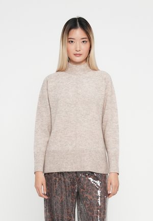 Ljusbeige polotröja med texturerad stickning, ribbade ärmmuddar och nederkant, som har en avslappnad passform och subtila sömnadsdetaljer.