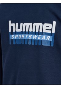 T-shirt in cotone blu navy con un audace logo "hummel" in bianco e "SPORTSWEAR" in azzurro chiaro, caratterizzato da uno sfondo a gradiente testurizzato.