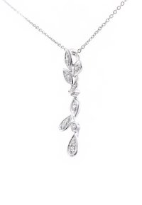 pakabukas ant kaklo, turintis sidabrinę grandinėlę ir lapo formos pakabuką, išdėstytą su skaidriais brangakmeniais, rodantis elegantišką, pailgą dizainą.