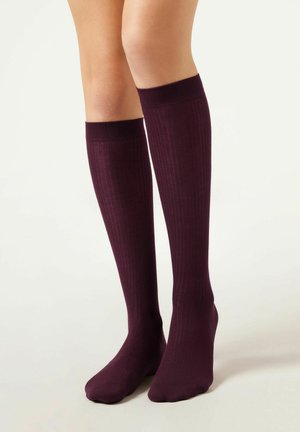 Knielange sokken in donkerburgundy, met ribbeltextuur, een soepele afwerking, elastische boord en een verstevigde teen voor duurzaamheid.