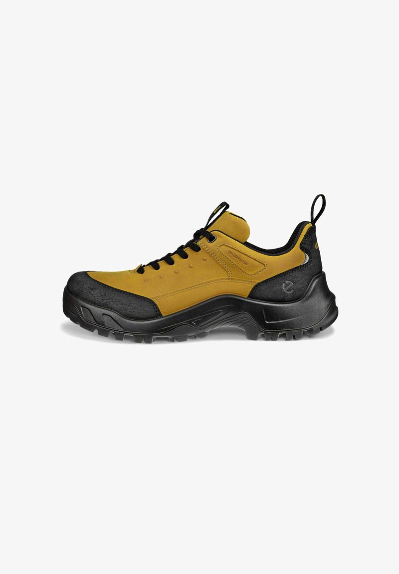 Scarpa da trekking impermeabile con tomaia in suede giallo e punta in gomma nera. Presenta un robusto design con lacci e un pratico cinturino per il tiraggio.