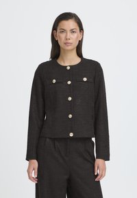 Giacca nera con trama, dal design corto, scollo rotondo e tasche frontali, caratterizzata da grandi bottoni dorati come dettagli.