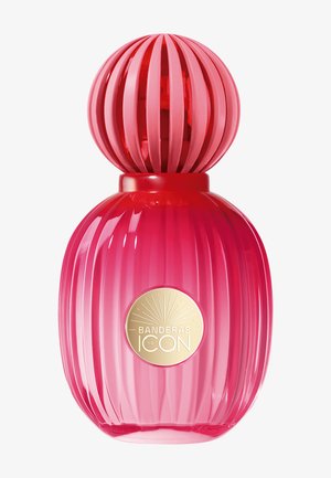 Flacon de parfum rose brillant avec une texture côtelée et un bouchon rond côtelé, avec une étiquette dorée portant l'inscription "Banderas The Icon."