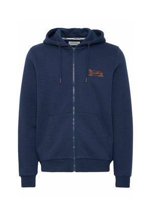 Jūras flotes zips veste, izgatavota no mīkstas auduma, ar priekšējo kabatu un auklu. Uz kreisā krūša ir oranža izšūta uzraksts.