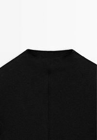 Maglione nero con collo alto caratterizzato da una texture a costine, design senza cuciture sul retro e silhouette aderente. Stile semplice e minimalista.