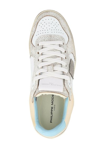 Witte sneaker met tekstuurbewerking in lichtgrijs, crèmekleurige hak en lichtblauwe binnenvoering. Heeft een geperforeerde neus en witte veters.