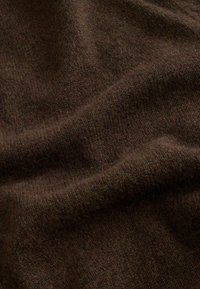 Barna gyapjúszövet puha, texturált felülettel és enyhén szabálytalan szövésmintával. Az anyag melegnek és kényelmesnek tűnik, finom színárnyalat-változásokkal.