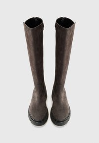 Bottes en suédine grise, arrivant jusqu'aux genoux, avec une finition texturée, des semelles en caoutchouc plates et des fermetures éclair sur les côtés pour un enfilage facile.