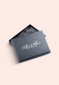Grå tekstureret smykkeskrin med låg, der er let åbent, hvilket afslører sort silkepapir indeni. "Sofia Milani JEWELS" logo præget på toppen.