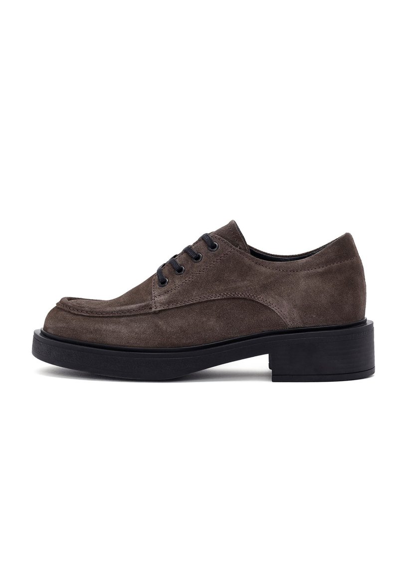 Brown suede lace-up shoe with a rounded toe, black eyelets, and a thick black sole. Smooth texture and minimalistic design.