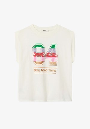 Le t-shirt crème à manches courtes arbore un graphique coloré « 84 » en points et un texte doré pailleté disant « Only Good Times ». Fabriqué en coton doux.
