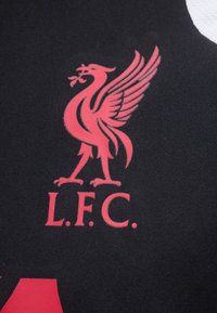 Έμβλημα κόκκινου πουλιού του Liverpool σε μαύρο ύφασμα με τα γράμματα "L.F.C.", που αντιπροσωπεύει το λογότυπο της Liverpool Football Club.