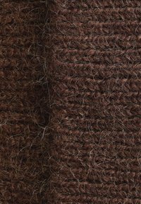 Brown woven fabric with a textured surface, featuring a soft, fuzzy appearance and varying thickness in the strands, creating depth.