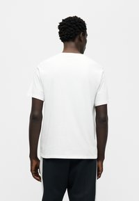 Λευκό κοντομάνικο μπλουζάκι με στρογγυλή λαιμόκοψη και πλαϊνές ραφές. Ομαλό βαμβακερό ύφασμα με άνετη εφαρμογή, μινιμαλιστικός σχεδιασμός.