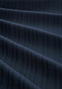 Tissu bleu foncé avec une texture côtelée verticale régulièrement espacée et des plis doux créant des ombres délicates sur la surface.