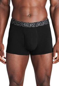 Schwarze Boxershorts aus weichem, dehnbarem Material. Sie verfügen über einen elastischen Bund mit "UNDER ARMOUR"-Logo und einem vorderen Pouch-Design.