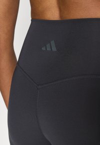 Mustad retuusid elastse kangaga, millel on kõrge vöökoht ja lamedad õmblused. Tagaküljel diskreetne tume logodetail.