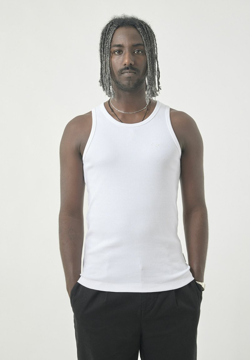 Weißes, geripptes Tanktop mit Rundhalsausschnitt, aus einem Baumwollmix gefertigt. Hat eine schlanke Passform, ohne sichtbare Logos oder Muster.