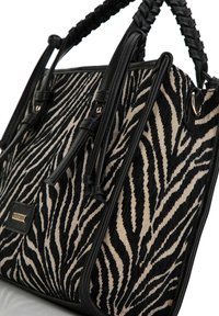 Borsa a tracolla con stampa zebra, caratterizzata da un corpo in tessuto texturizzato con strisce nere e beige, compleatata da manici e dettagli in pelle nera.
