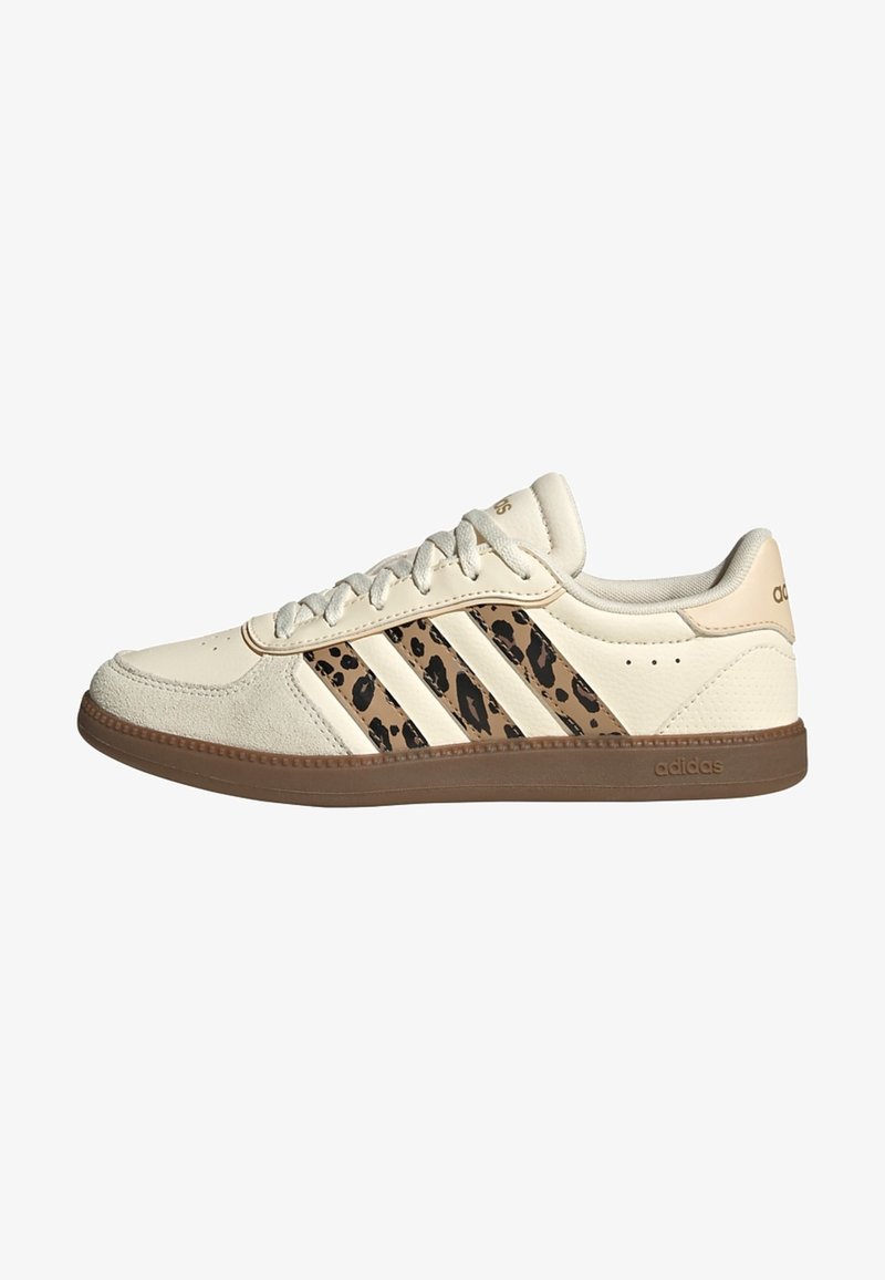Kremowy tenis Adidas z paskami w panterkę, beżowym noskiem z zamszu i brązową gumową podeszwą, widoczny od zewnętrznej strony.