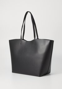 Black tote bag made of smooth faux leather, features two long handles, open top, and angled sides for a spacious design.
