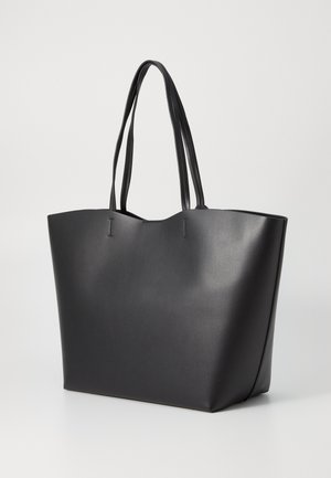 Svart tote-väska i slät konstläder, med två långa handtag, öppet topp och vinklade sidor för en rymlig design.