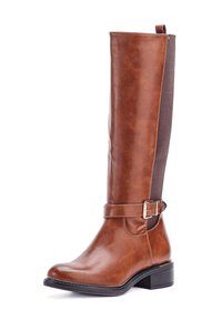 Bota alta de cuero marrón con suela de goma negra, tacón bajo tipo bloque, correa con hebilla lateral y panel elástico en la parte posterior para ajuste.