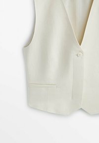 Veste sans manches beige clair avec une fermeture à un seul bouton et une poche droite sur le côté gauche.