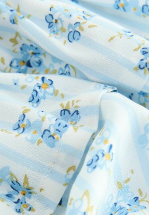 Kangas, jossa on vaaleansininen tausta, vaakasuoria raitoja ja pieniä kukkakuvioita sinisen ja keltaisen sävyissä. Pehmeä koostumus.