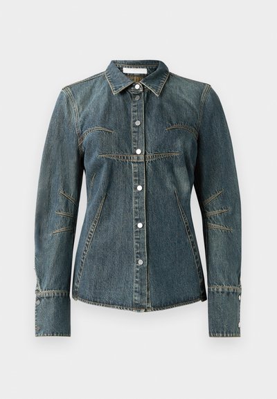 Jeans jakna s klasičnim ovratnikom, temno modre barve, z zapiranjem na gumb in dekorativnimi šivi na rokavih in telesu. Ima srebrne gumbe.